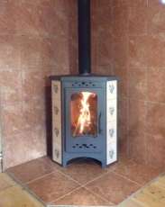 Недорогая печь-камин Бавария угловая с плитой незабудка Амазонка бай фото в интерьере в Бресте